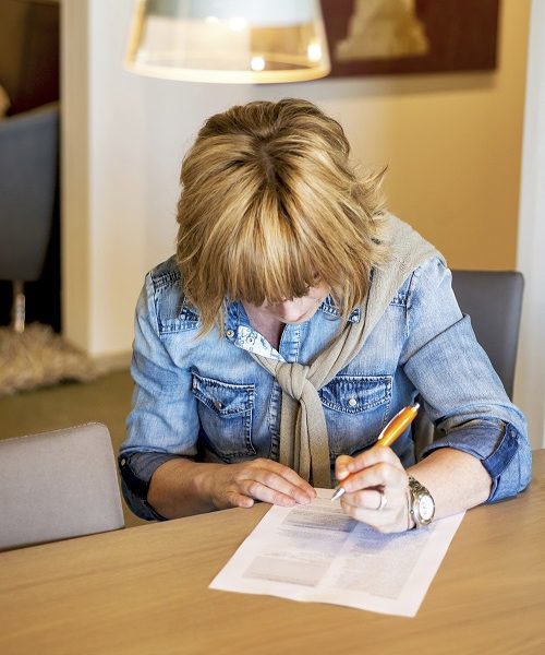 woman filling out benefit claim form