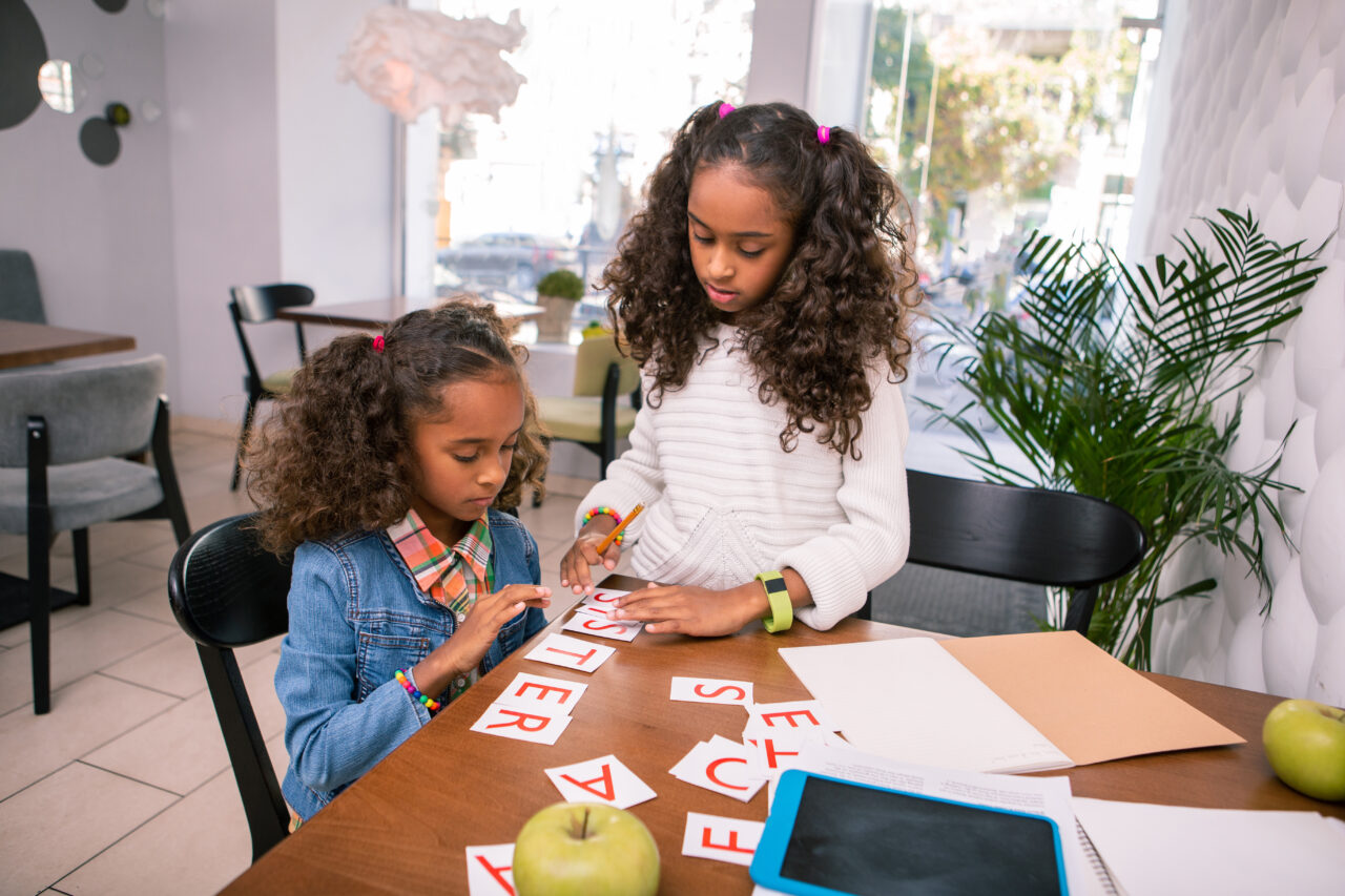 sibling carers playing cards at table