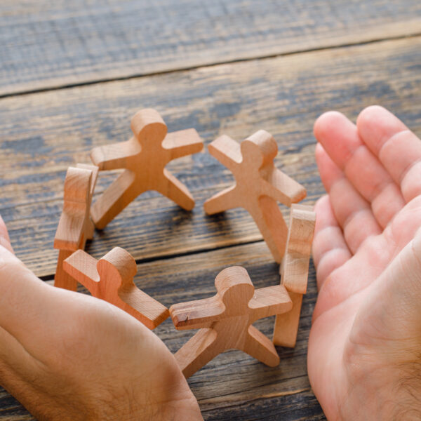 hands shielding wooden figures